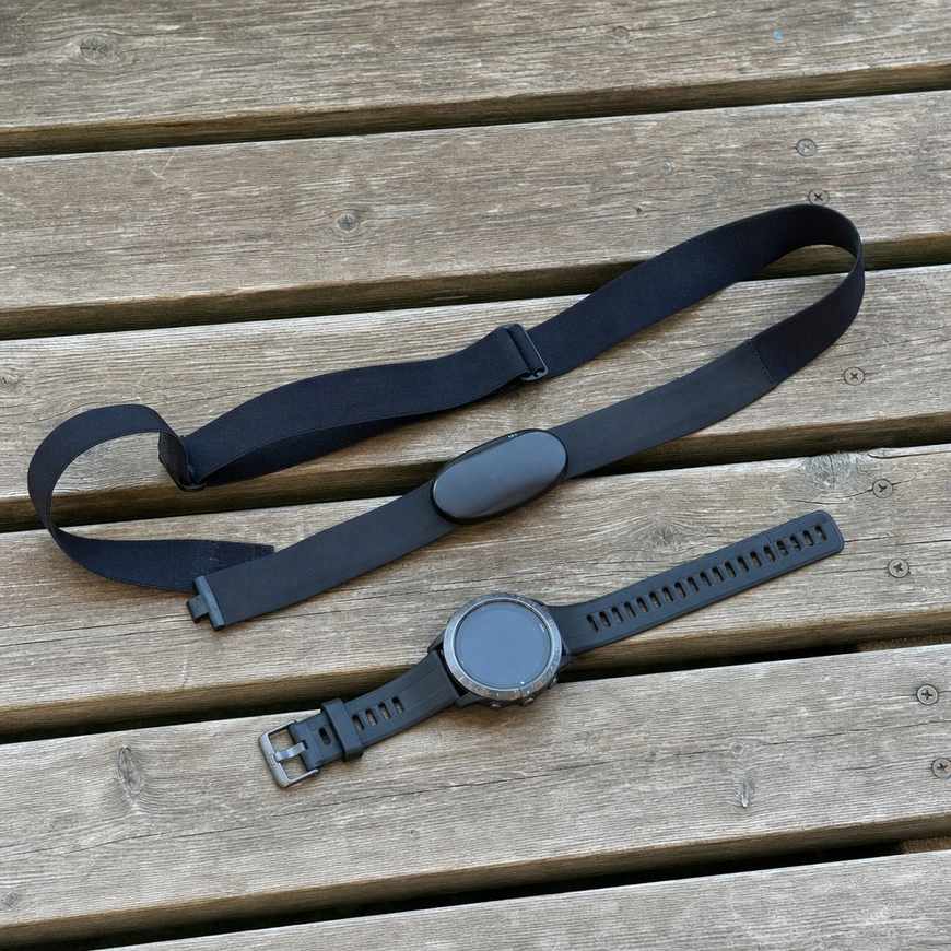 A heart-rate chest strap and watch on a bench