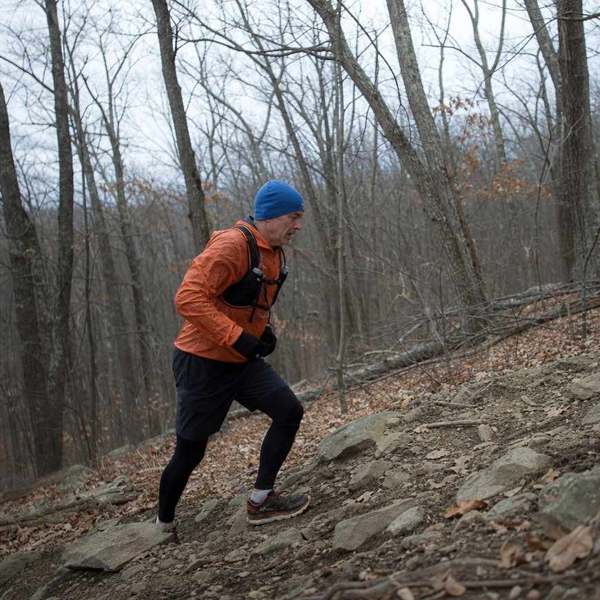 A runner climbing a forest trail