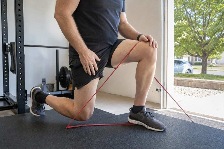A runner doing a single-leg strength move with a resistance band